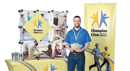 Promotional tradeshow items that include a vertical banner, display and table throw